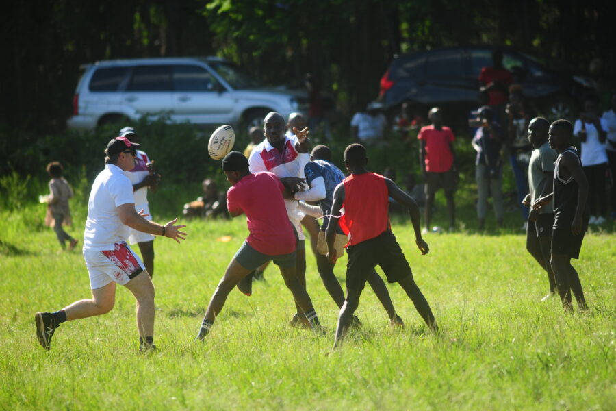 Shamas chairman Tito Oduk offloads the ball under a tackle by Shamas U18 boys at the Tatu City primary on Friday. Photo Courtesy/Alex Njue