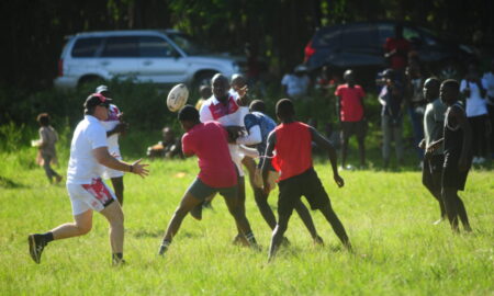 Shamas chairman Tito Oduk offloads the ball under a tackle by Shamas U18 boys at the Tatu City primary on Friday. Photo Courtesy/Alex Njue