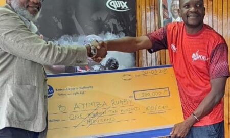 Jack Bwana GM Marketing & Business Development handing a 1.2M sponsorship cheque to Quicks Nyakwaka Chairman Organizing committee Benjamin Ayimba Rugby Legacy Tournament.