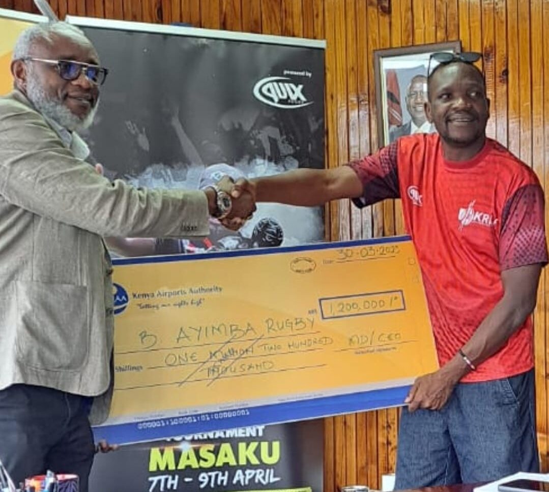 Jack Bwana GM Marketing & Business Development handing a 1.2M sponsorship cheque to Quicks Nyakwaka Chairman Organizing committee Benjamin Ayimba Rugby Legacy Tournament.