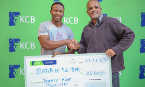 KCB Rugby scrum-half Samuel Asati receives cheque. PHOTO/KCB Rugby