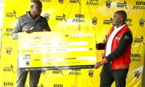 KBL MD Mark Ociti hands over a dummy cheque to KRU VC Moses Ndale. PHOTO/Mahlon Lichuma