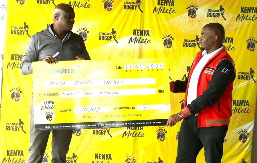 KBL MD Mark Ociti hands over a dummy cheque to KRU VC Moses Ndale. PHOTO/Mahlon Lichuma