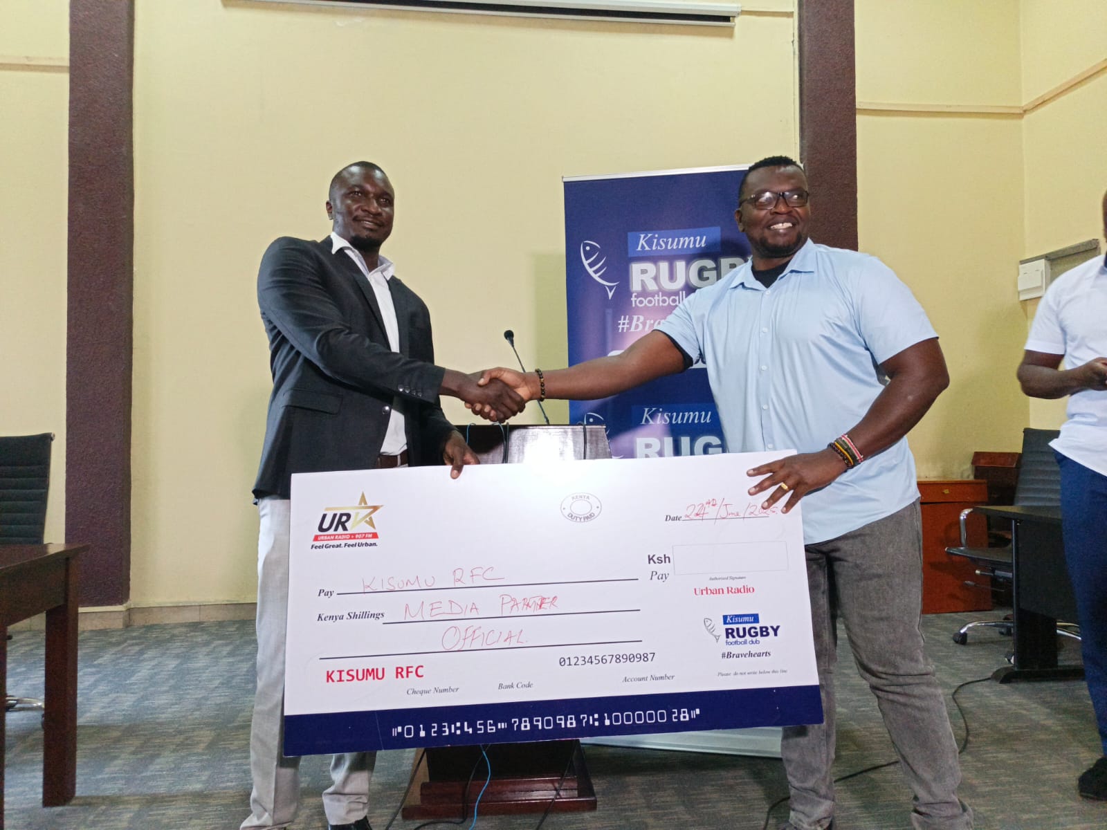 Kisumu RFC chairman Dr Gabriel Ouma receives a dummy cheque Urban Radio. PHOTO/Brian Mwenje